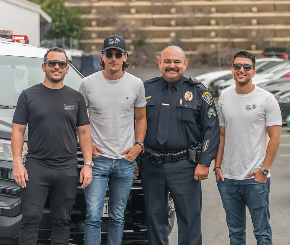 Fast Lane Drive founders posing with a San Diego Police officer.